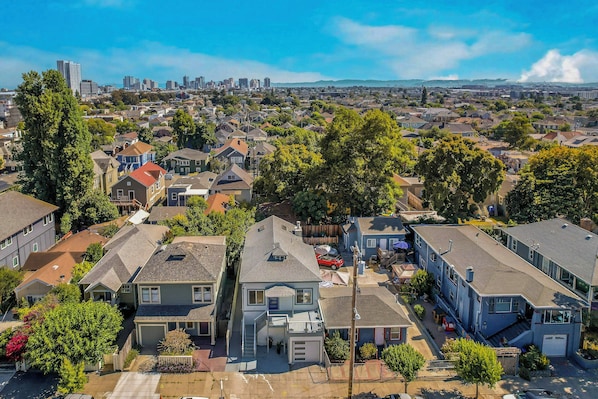 A residential area with houses, trees, and a distant city skyline. - 2 Mi to San Francisco Bay: Family Home w/ Decks! (Oakland)