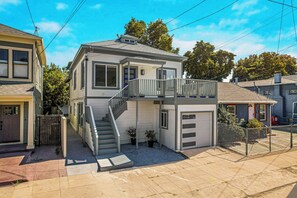 Ein zweistöckiges Haus mit Balkon, überdachter Veranda und Garage.