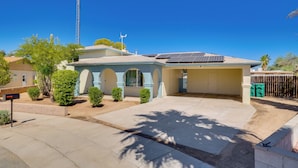 A residential house with a garage, solar panels, and a clear blue sky. - 6 Mi to Saguaro Natl Park! Family Home w/ Patio (Tucson)