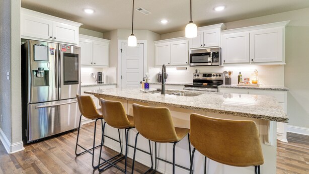 A modern kitchen with white cabinets, stainless steel appliances, a granite countertop, and four bar stools. - Riders Retreat! Modern Home By Bella Vista Trails (Bella Vista)