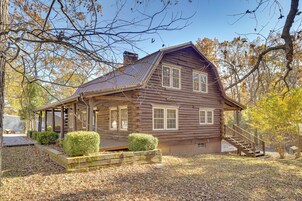 A log cabin with a porch, a chimney, and a staircase leading to the entrance.