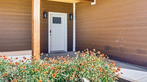 A wooden house with a white door, a porch, and a flower bed in front. - Hike & Ski! Home w/ Dog-friendly Yard in Eagar (Eagar)