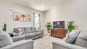 A modern living room with a grey sofa set, a wooden cabinet, and a flat-screen TV. - Hike & Ski! Home w/ Dog-friendly Yard in Eagar (Eagar)