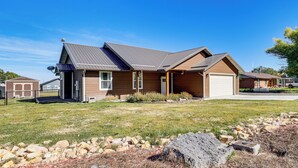 A single-story house with a sloped roof, a garage, and a well-maintained lawn. - Hike & Ski! Home w/ Dog-friendly Yard in Eagar (Eagar)