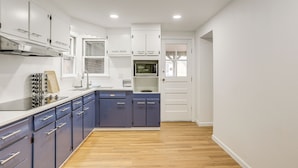 A modern kitchen with white cabinets, a microwave, and a sink. - Updated Getaway w/ Sauna & Yard in Bloomsbury! (Bloomsbury)