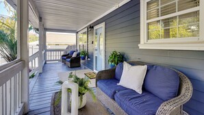 A covered porch with a blue sofa, wicker chairs, and potted plants. - Coastal Convenience! Mt Pleasant Gem 2 Mi to Ocean (Mount Pleasant)