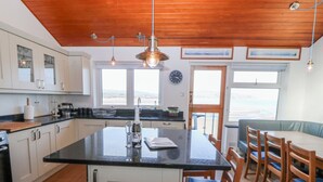 Une cuisine dotée d’un îlot central, de meubles en bois et offrant une vue sur l’extérieur.