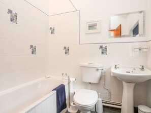 A modern bathroom with a bathtub, toilet, and sink. - Bryn Bach (Pentraeth)