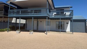 A two-story house with a balcony, a garage, and a gravel driveway. - Seaviews at Stansbury - Modern and spacious! Off Peak special available! (Stansbury)