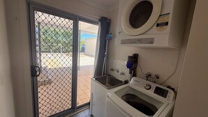 A compact laundry room with a washing machine, a dryer, and a small sink. - Seaviews at Stansbury - Modern and spacious! Off Peak special available! (Stansbury)