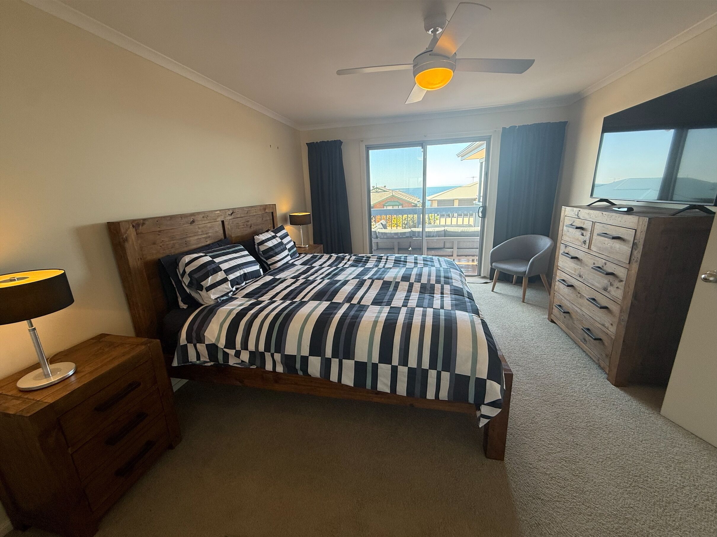 Ein Schlafzimmer mit einem Bett, einem Holzschrank und einem Deckenventilator.