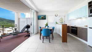 Una cocina moderna con comedor, un balcón con parrilla y vistas al paisaje.