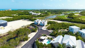 Una località balneare con diversi edifici, un campo da golf e una vasta distesa d'acqua.