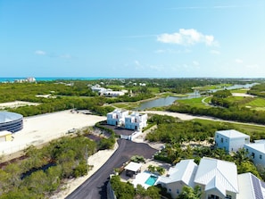 Un resort costero con varias construcciones, un campo de golf y una extensa masa de agua.