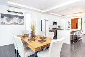 A modern kitchen with white cabinets, a built-in microwave, and a refrigerator. - NEW Villa Golf Course views, Roof Top Hot Tub, near Grace Bay Beach- Gabriella 2 (Grace Bay)