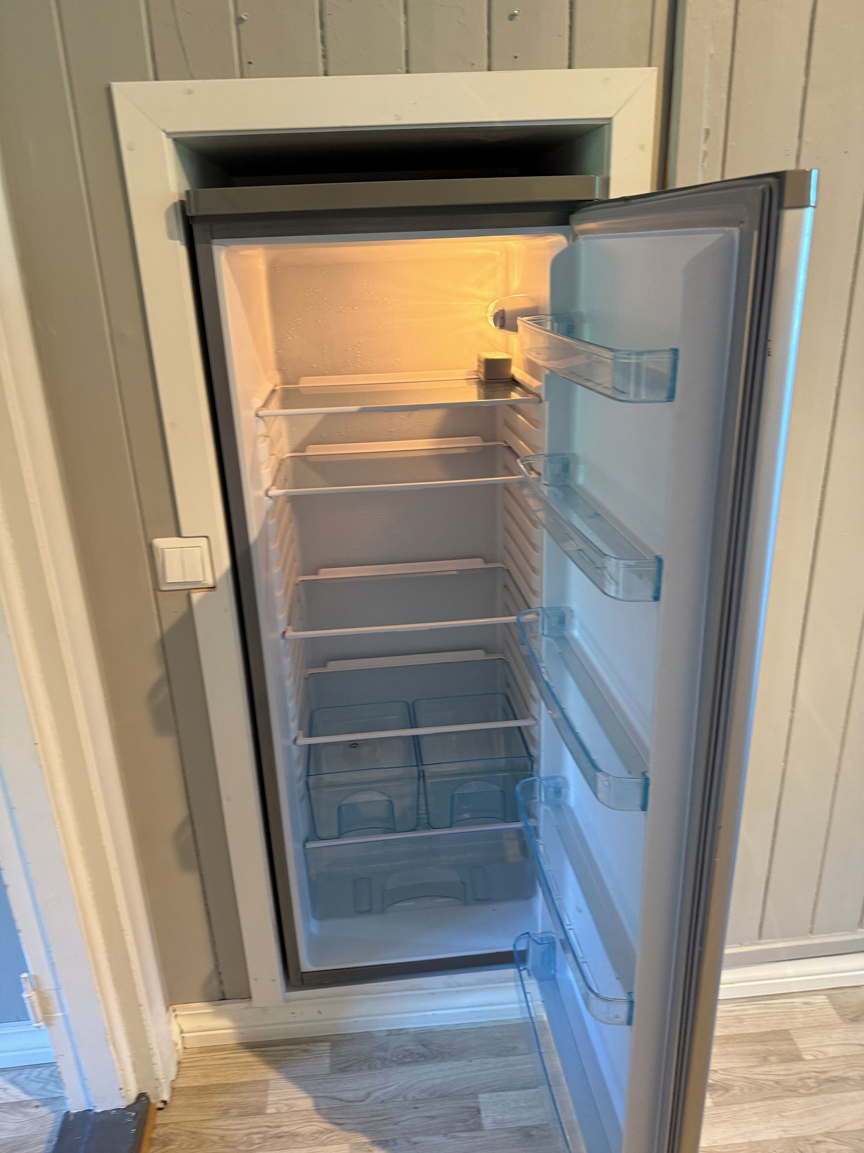 An open refrigerator with multiple shelves and a freezer compartment.