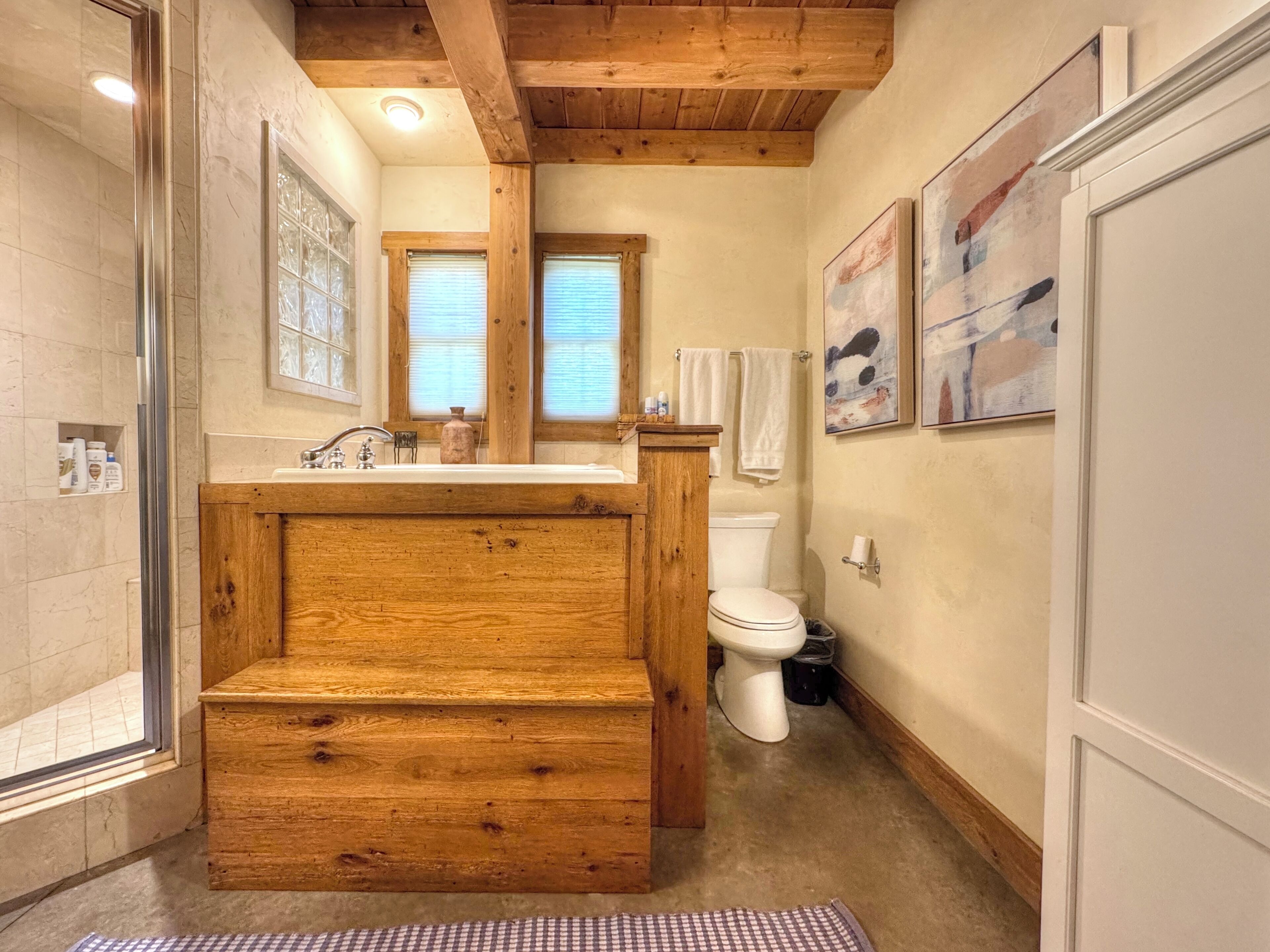 Ein Badezimmer mit einem Holzkosmetikschrank, einer Duschkabine aus Glas und einer Toilette.