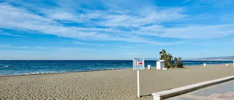 A beach with a sign indicating no swimming and no sunbathing.