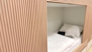 A bunk bed with a white mattress and a black object on it. - Rizq Luxurious Villa (Dubai)