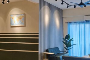 A hotel lobby with a reception desk, a seating area, a large plant, and a world map on the wall. - Pavilionvillie M1T584 by Irainbow (Kinta)