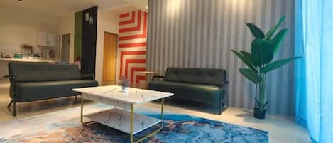 Una sala de estar moderna con un sofá, una mesa de centro y una planta grande.