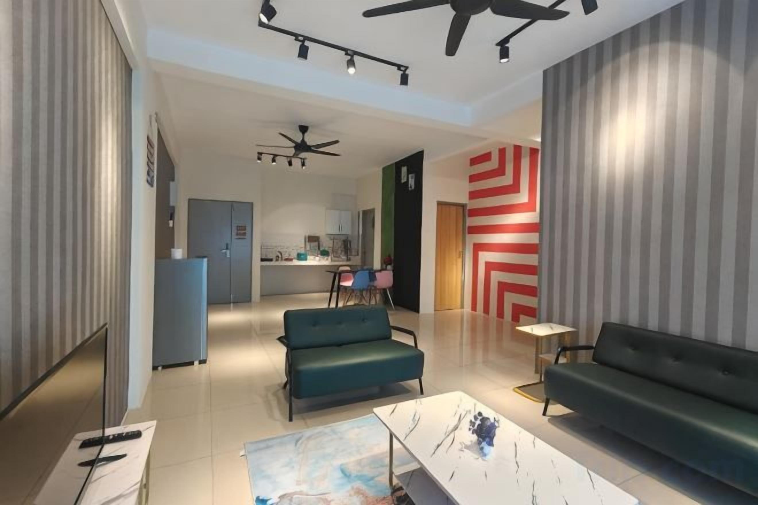 A modern living room with a sofa, a coffee table, and a TV. There is a kitchen in the background with a dining area.