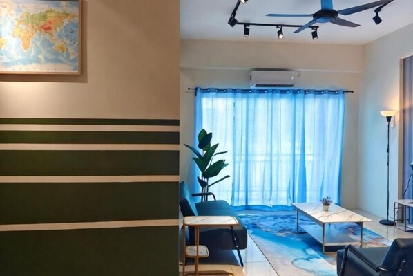 A room with a ceiling fan, a map on the wall, a dining table, and a large window with curtains.