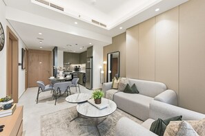 Una sala de estar moderna con un sofá gris, una mesa de centro y un comedor con sillas y una mesa.