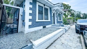 A two-story house with a blue exterior, a front porch, and a driveway. - The Duchess:Vintage Revived-Pets Welcome (Jacksonville)