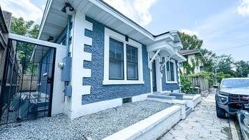 A two-story house with a blue exterior, a front porch, and a driveway.