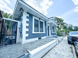 A two-story house with a blue exterior, a front porch, and a driveway. - The Duchess:Vintage Revived-Pets Welcome (Jacksonville)