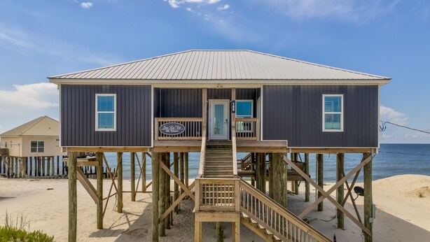 A wooden beach house with a balcony, a staircase, and a sign that reads "Sea La Vie 106 Villas". - Sea La Vie - 106 Velasco Ct 4 Bedroom Home (Dauphin Island)