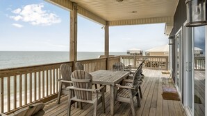 A wooden deck with a table and chairs, overlooking the ocean. - Sea La Vie - 106 Velasco Ct 4 Bedroom Home (Dauphin Island)