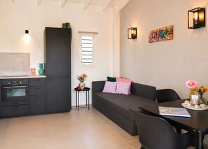 A modern living space with a kitchen, a dining area, and a sofa. - Bunitesa di bida Kas Iquana (Soto)