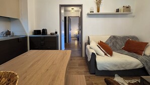 A modern living room with a sofa, coffee table, and kitchen area with a sink and appliances. - T3 apartment 50 meters from the slopes - Heart of the resort. (Les Deux Alpes)