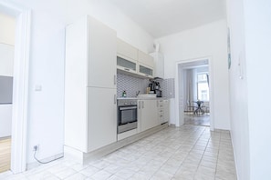 A modern kitchen with white cabinets, a built-in oven, and a coffee machine. - 2BR Apt Next to Vienna Vibrant Center (Vienna)