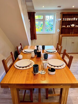Une table à manger dressée avec des assiettes, des tasses et un verre.