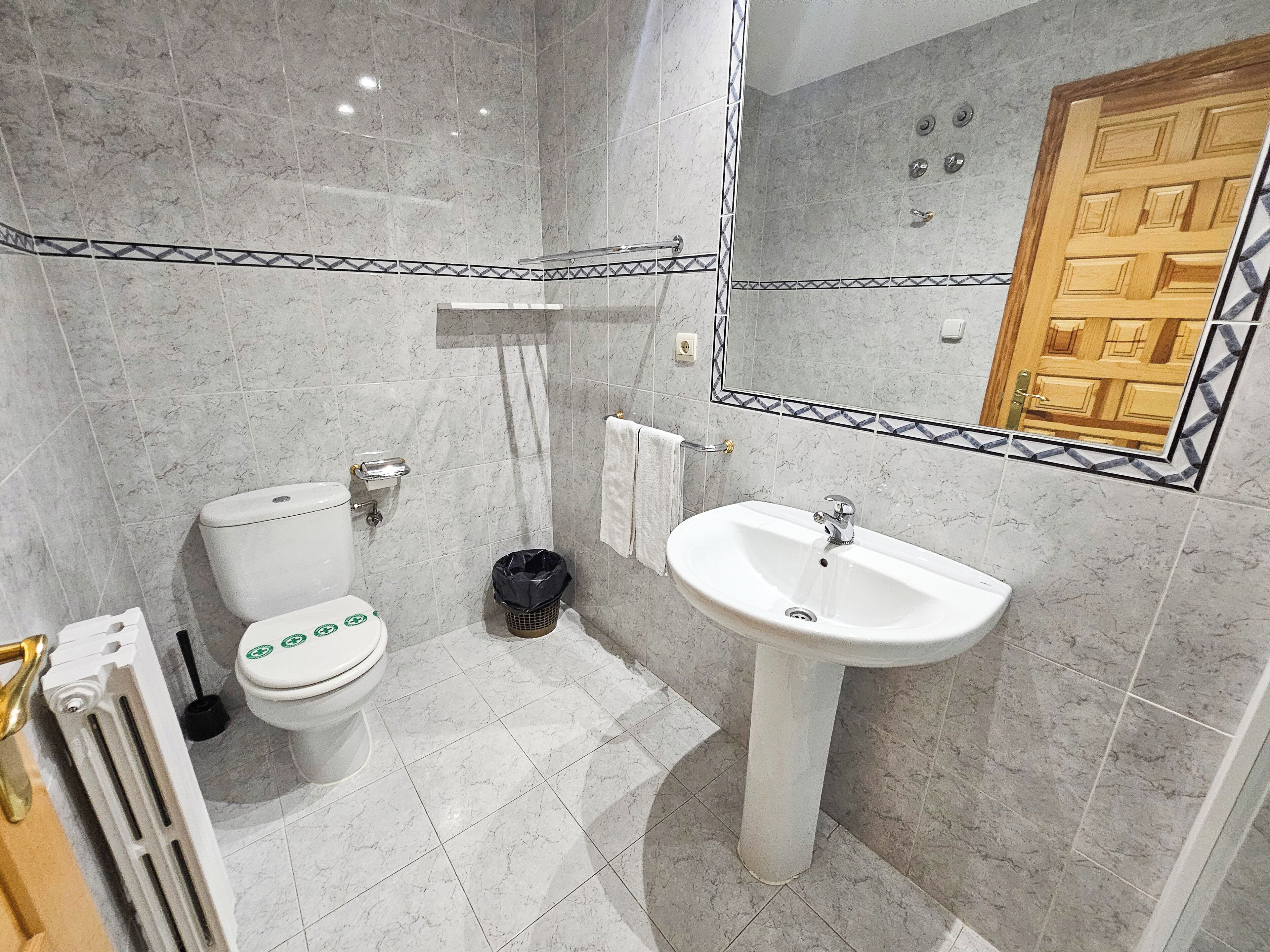 Een badkamer met toilet, wastafel en douche.