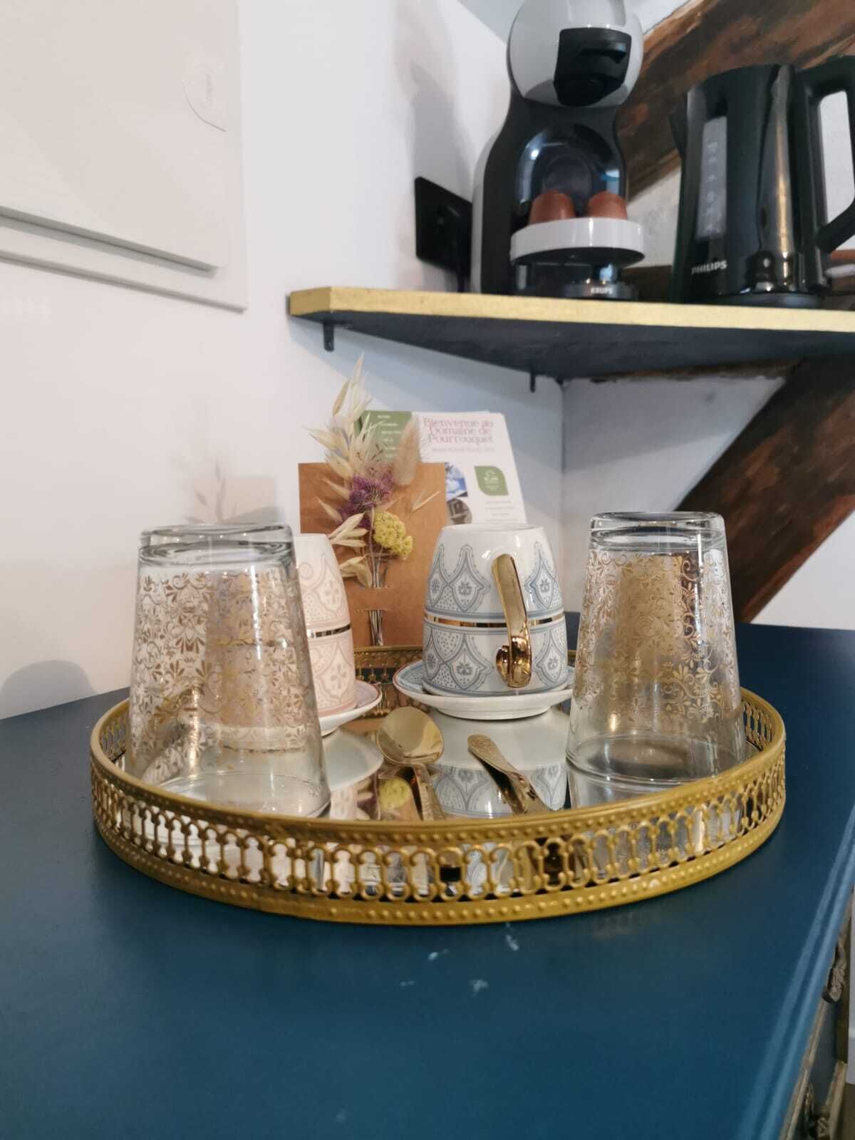 A tray with glassware and a teapot on a table.