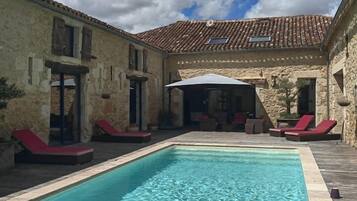 Een seizoensgebonden buitenzwembad en parasols bij het zwembad