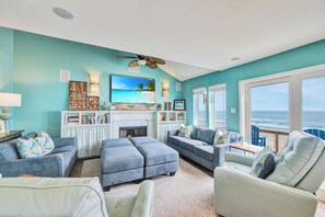 A living room with a fireplace, a large TV, and a view of the ocean. - Breathtaking ocean views! King bedroom on the 3rd floor with amazing views of th (Port Aransas)
