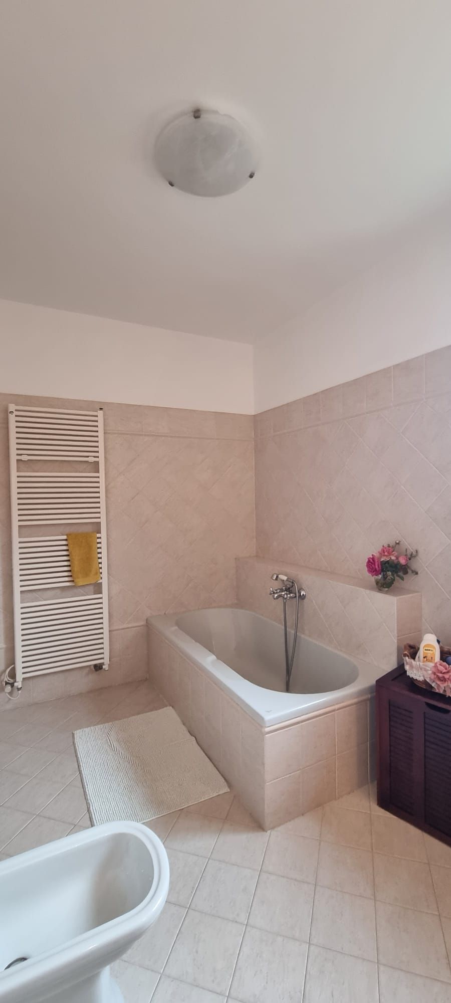 A bathroom with a bathtub, a toilet, and a towel rack.
