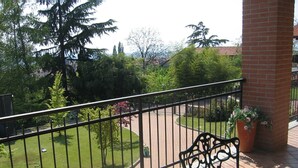 A balcony with a metal railing, a potted plant, and a brick pillar. - Detached family home in Piverone, near Lake Viverone (Piverone)