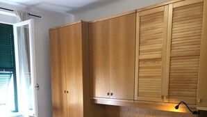 A bedroom with a bed, wooden wardrobe, and a window with curtains. - Casajeanmarc in Moneglia, a picturesque Ligurian town a stone's throw from the 5 Terre (Moneglia)