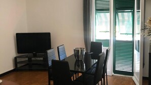 A dining area with a table, chairs, a TV, and a ceiling fan. - Casajeanmarc in Moneglia, a picturesque Ligurian town a stone's throw from the 5 Terre (Moneglia)