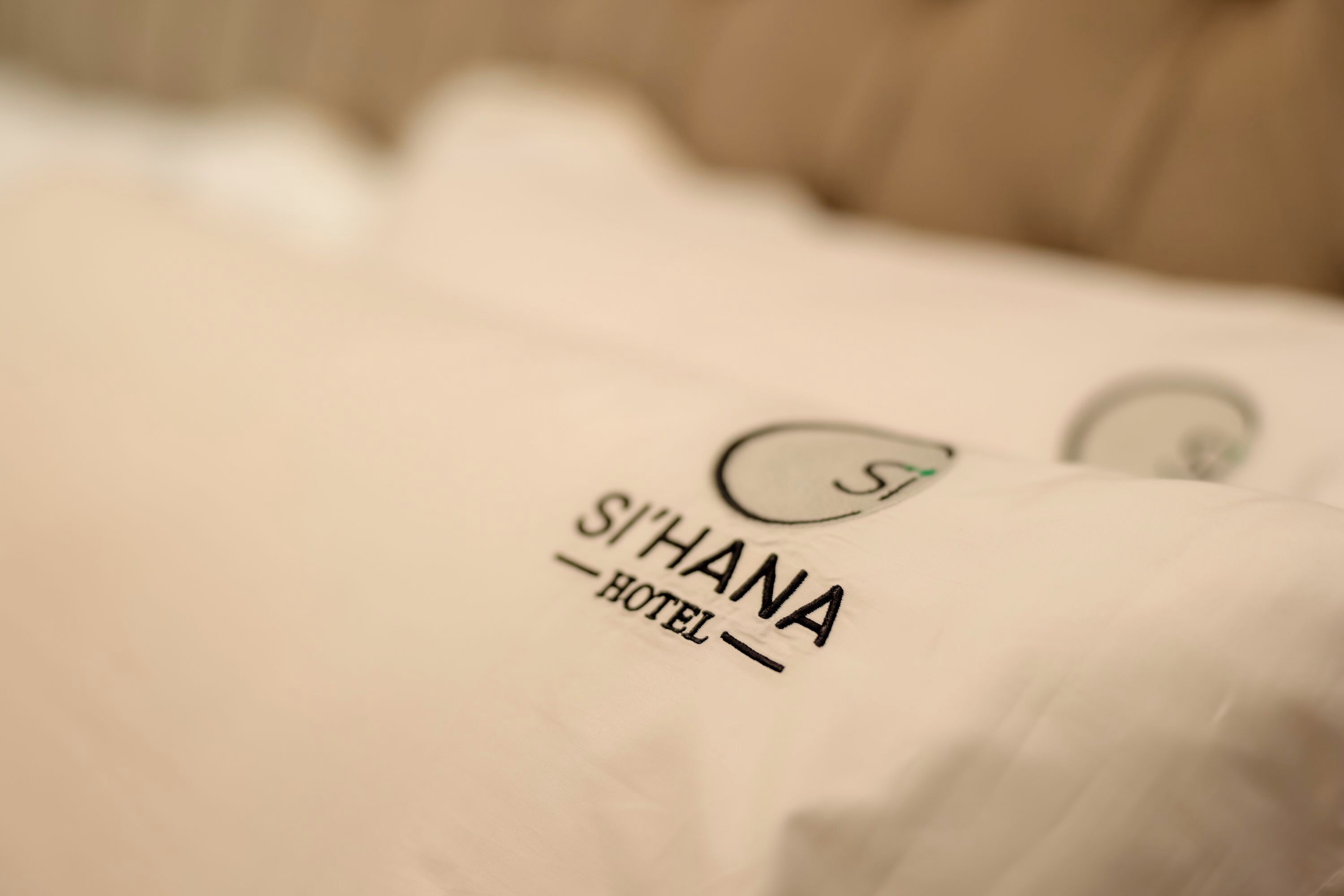 Un oreiller orné du logo et du nom de l’hôtel Si’hana.