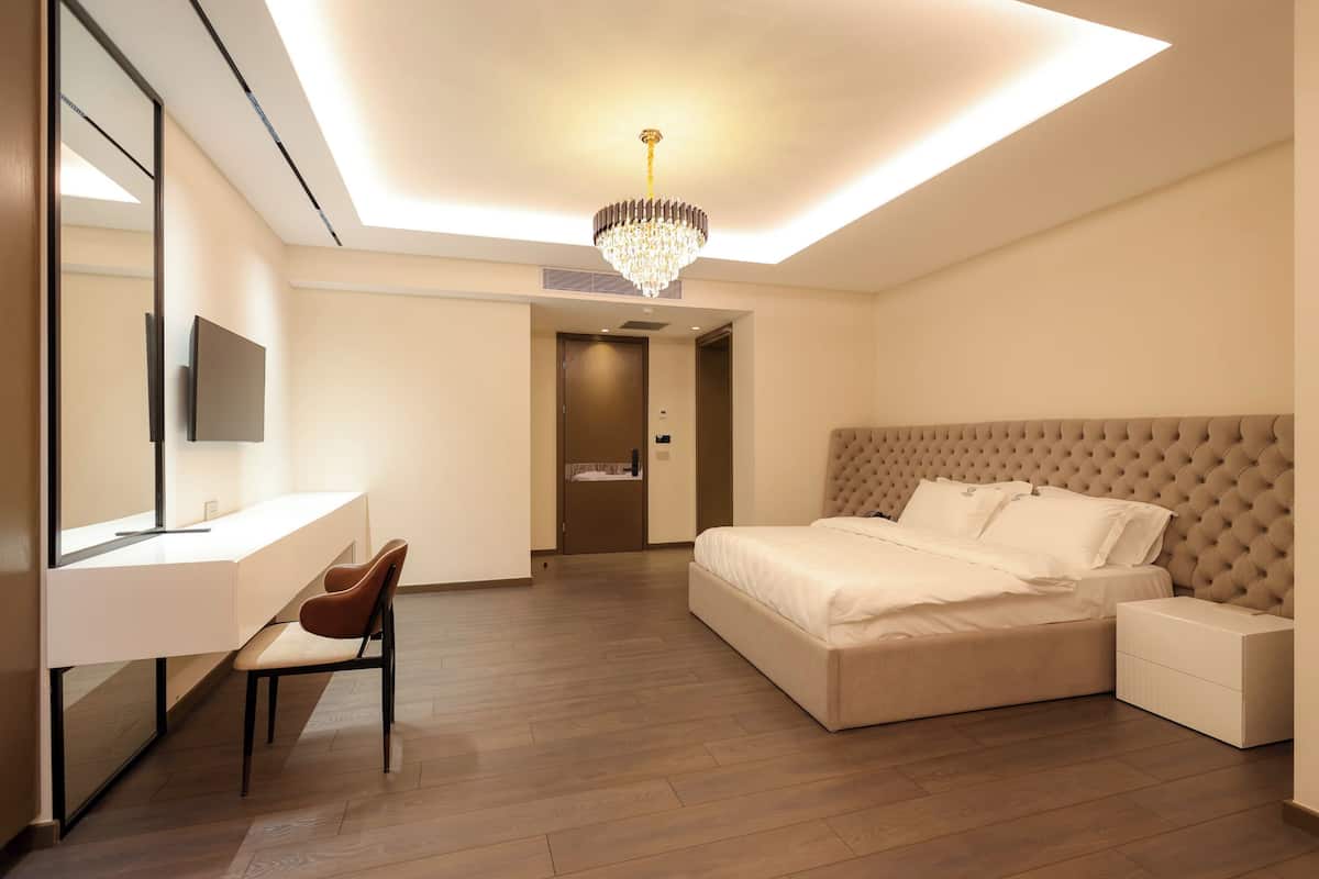 Un dormitorio moderno con una cama grande, un escritorio y una silla.