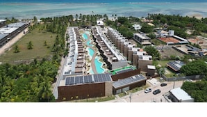 A resort with a pool, solar panels, and a view of the ocean.