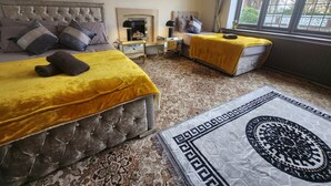 A bedroom with two beds, a nightstand, a lamp, and a window with a view. - Room 1 Cottage   White House Old Trafford  Manchester (Stretford)