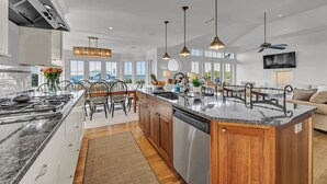 A modern kitchen with a central island, stainless steel appliances, and pendant lighting. - 7-bedroom water view compound featuring a main house and annex. (Southport)